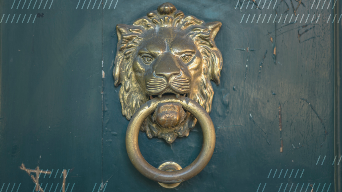 A door knocker in the shape of a golden lion's head, on a teal door
