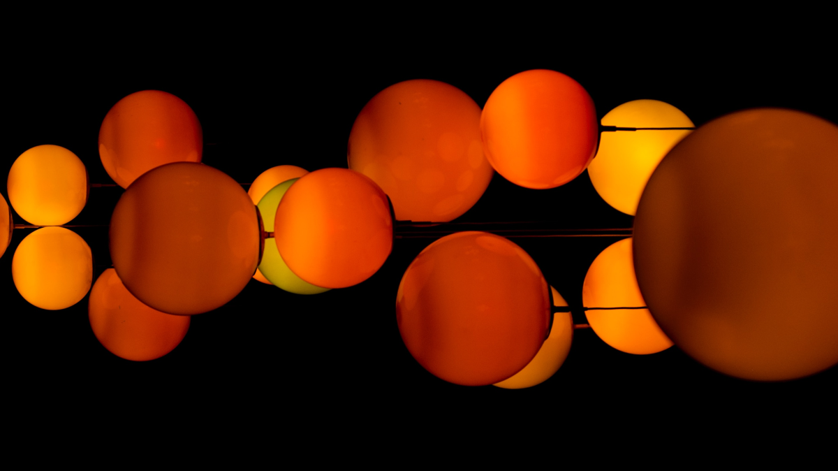 Orange baubles of different sizes floating near each other